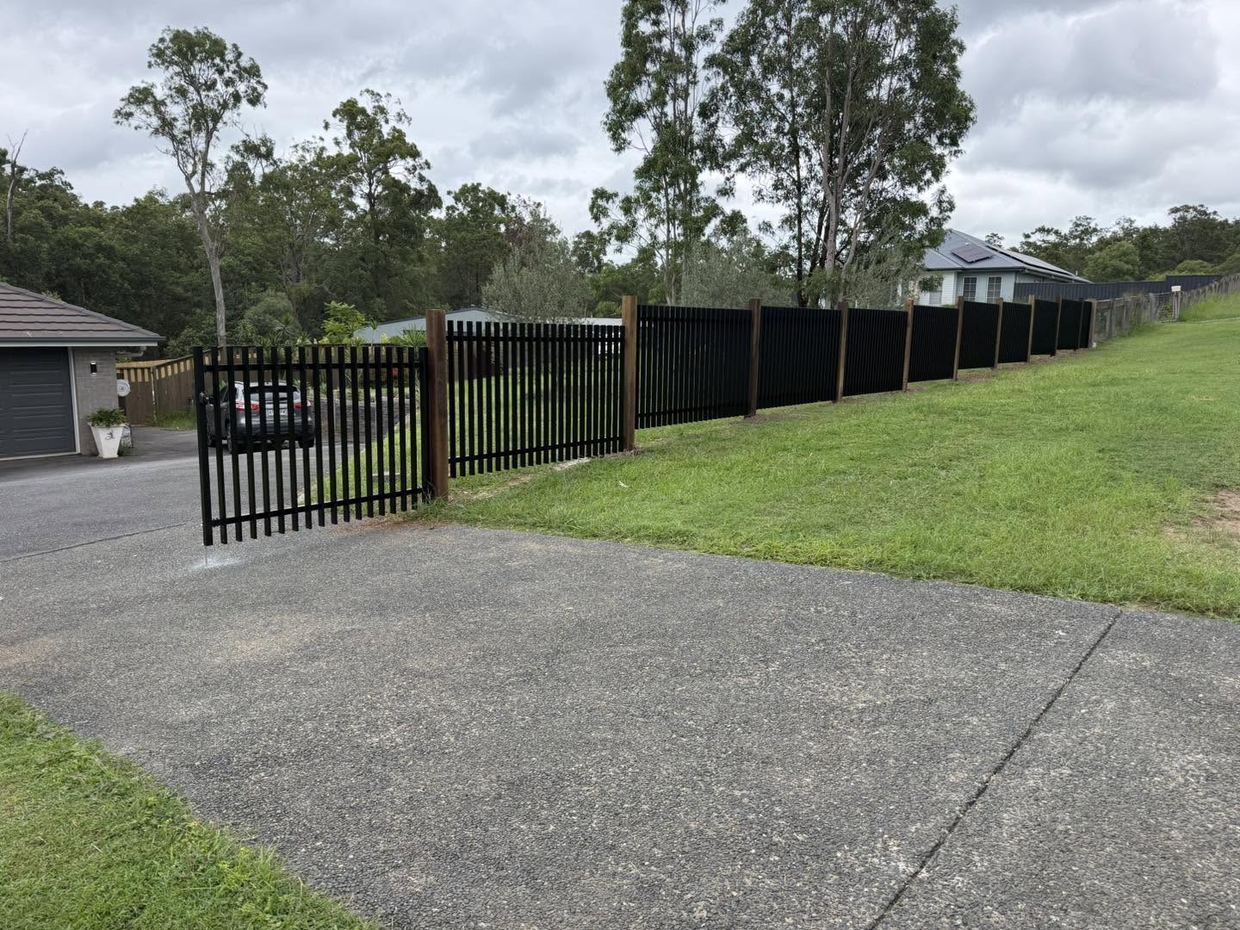Black aluminium tubular fence and gate to a driveway
